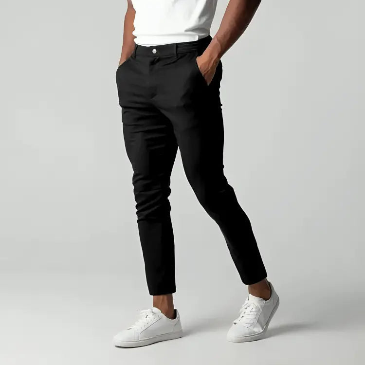 Pantaloni chino blu scuro da uomo, eleganti e moderni, abbinati a scarpe da ginnastica bianche. Ideali per look casual e formali.