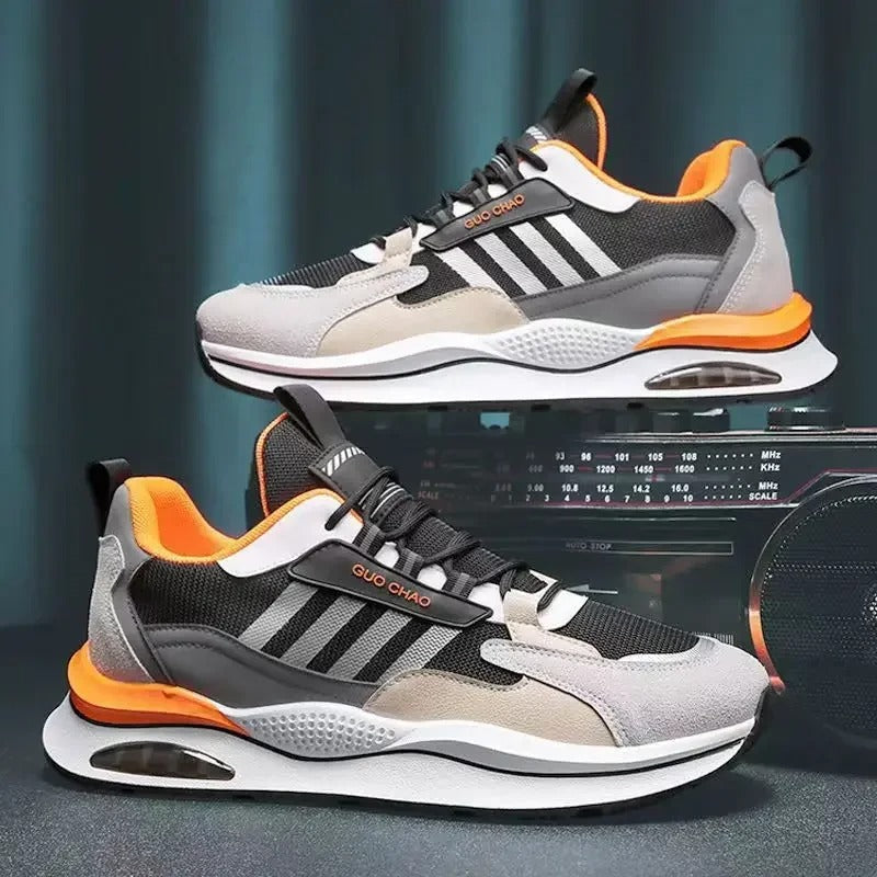 Grijze en witte sportschoenen met groene accenten, gedragen door een persoon in zwarte jeans. Moderne sneakers, comfortabele hardloopschoenen.